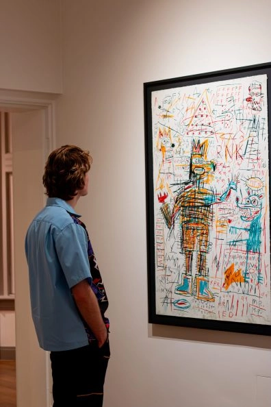 Visitor viewing Basquiat’s Figure Portfolio in gallery, basquiat in amsterdam.