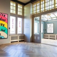 Room at Moco Museum Amsterdam featuring black heart artworks and handwritten quotes by Robbie Williams. Colorful wall piece by Robbie Williams reading “I Deserve Every Drop of Love You've Got to Give,” shown at Moco Museum Amsterdam. Room at Moco Museum Amsterdam featuring black heart artworks and handwritten quotes by Robbie Williams. Colorful wall piece by Robbie Williams reading “I Deserve Every Drop of Love You've Got to Give,” shown at Moco Museum Amsterdam.