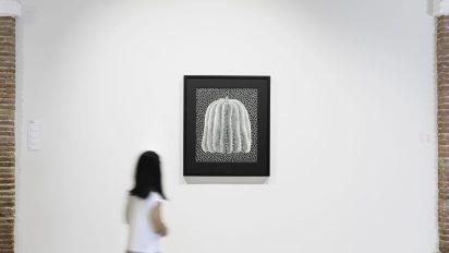 Visiteur observant la citrouille emblématique de Kusama.