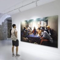 Visitor observing Jesus is my Homeboy: The Last Supper by LaChapelle, featuring modern figures in streetwear around a table inspired by the Last Supper.