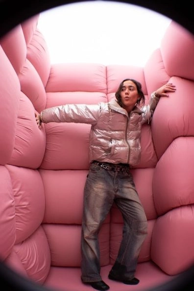 Visitor leaning inside pink padded room from Dreams by Andrés Reisinger, Moco Museum Amsterdam. Visitor leaning inside pink padded room from Dreams by Andrés Reisinger, Moco Museum Amsterdam.