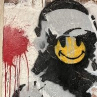Banksy's Smiling Copper stencil met geel smiley-gezicht, te zien in Amsterdam. Banksy's Smiling Copper stencil met geel smiley-gezicht, te zien in Amsterdam.