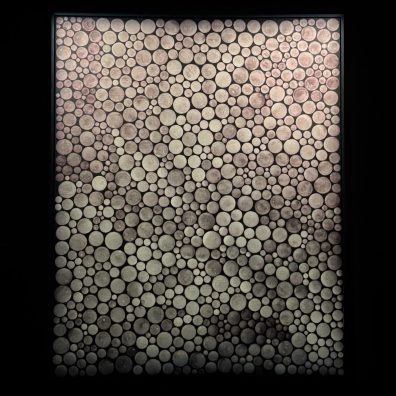 Opera tipo lightbox pixelata di Kusama in uno spazio espositivo buio al Moco Museum Amsterdam.