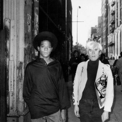 Black-and-white photo of Jean-Michel Basquiat and Andy Warhol.