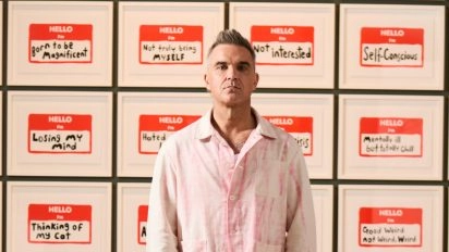 Robbie Williams stands in front of his HELLO I’m series at Confession of a Crowded Mind, Moco Museum Barcelona.