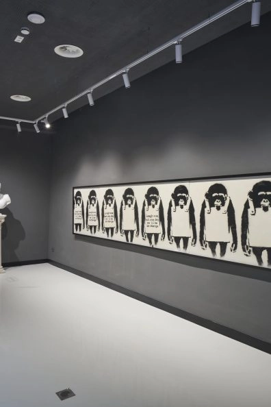Sala espositiva con la serie di poliziotti di Banksy al Moco Museum Barcelona