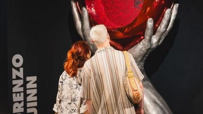Visiteurs regardant sculpture en ballon métallique avec cœur rouge de Lorenzo Quinn au Moco Museum London