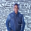 Robbie Williams davant d’una obra de text manuscrit en blanc i negre, part de la seva exposició al Moco Museum Amsterdam.