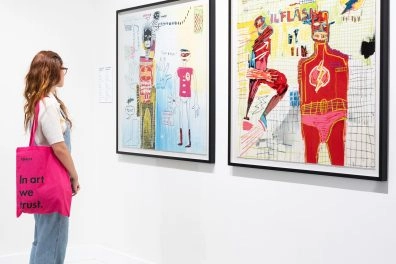 Visiteur observant des œuvres de Basquiat sur les super-héros au Moco Museum Barcelona