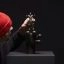 Frankey positioning miniature sculpture on oversized black hand at Moco Museum