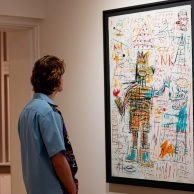 Visitant observant una obra acolorida de Jean-Michel Basquiat al Moco Museum Amsterdam. Visitant observant una obra acolorida de Jean-Michel Basquiat al Moco Museum Amsterdam.
