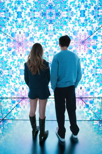 Visitors admiring vibrant floral digital room at Moco Museum Amsterdam.