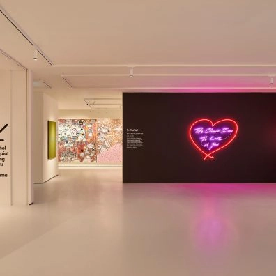 Interieur van Moco Museum London met neonhart van Tracey Emin op zwarte muur en graffiti op achtergrond