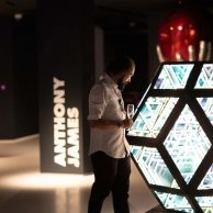 Visitantes observan instalación hexagonal espejada de Anthony James con texto digital en Moco Museum London