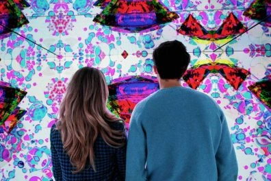 Couple admiring immersive digital art wall at Moco Museum Amsterdam.